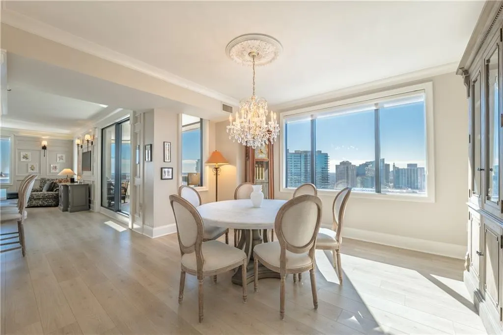 Dining room featuring light wood-type flooring, crown molding, baseboards, and an inviting chandelier