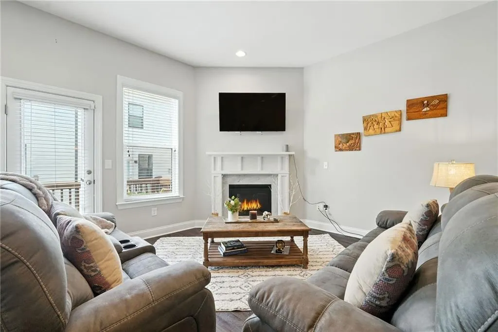 Living area with wood finished floors, a premium fireplace, and recessed lighting