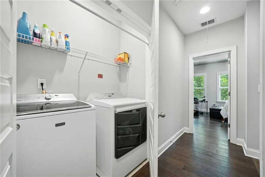 Laundry area with dark wood-style floors, independent washer and dryer, and recessed lighting