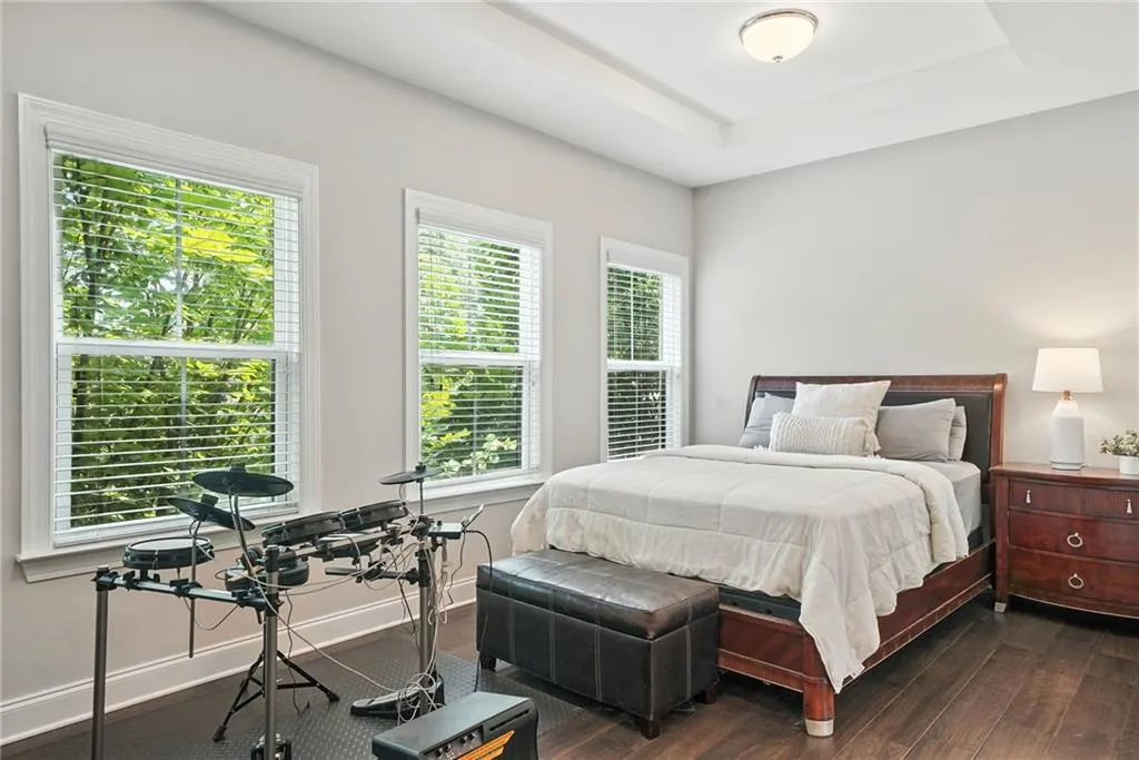 Bedroom featuring a tray ceiling and dark wood finished floors