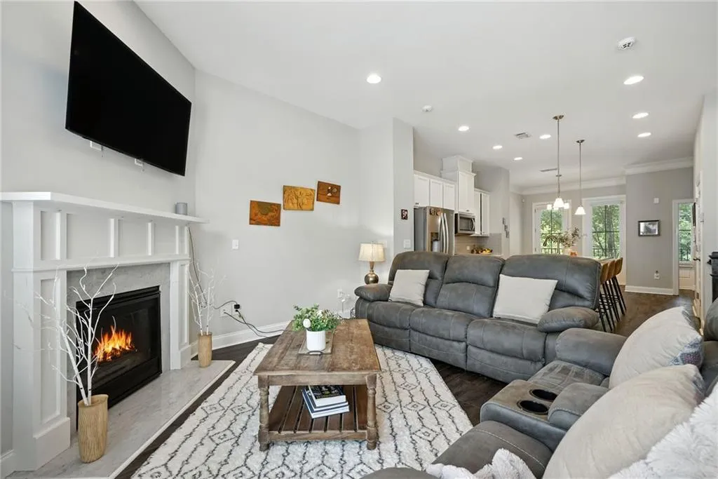 Living area with recessed lighting, wood finished floors, and a high end fireplace