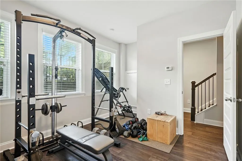 Workout area featuring dark wood-style floors and baseboards