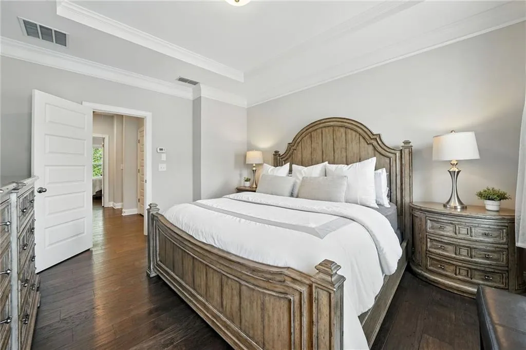 Bedroom featuring dark wood-style floors, crown molding, and a raised ceiling