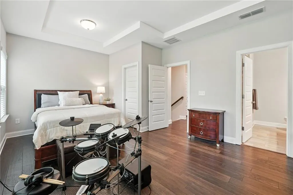 Bedroom featuring dark wood finished floors and connected bathroom