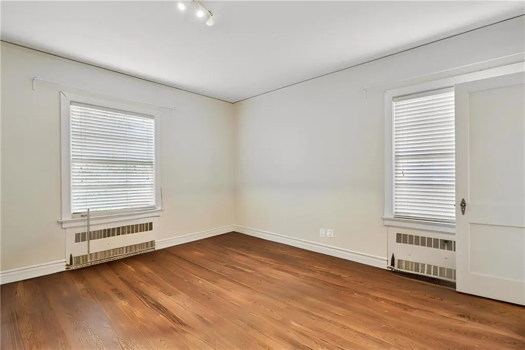 Bedroom with hardwood floors and a walk-in closet