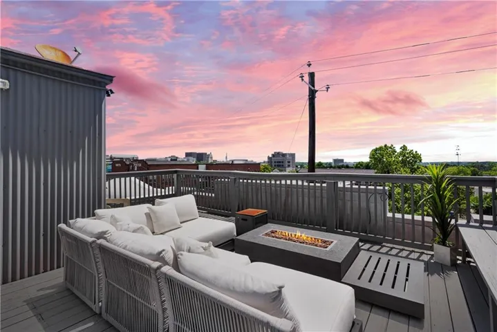 Rooftop deck featuring a fire pit, composite decking, and a perimeter railing
