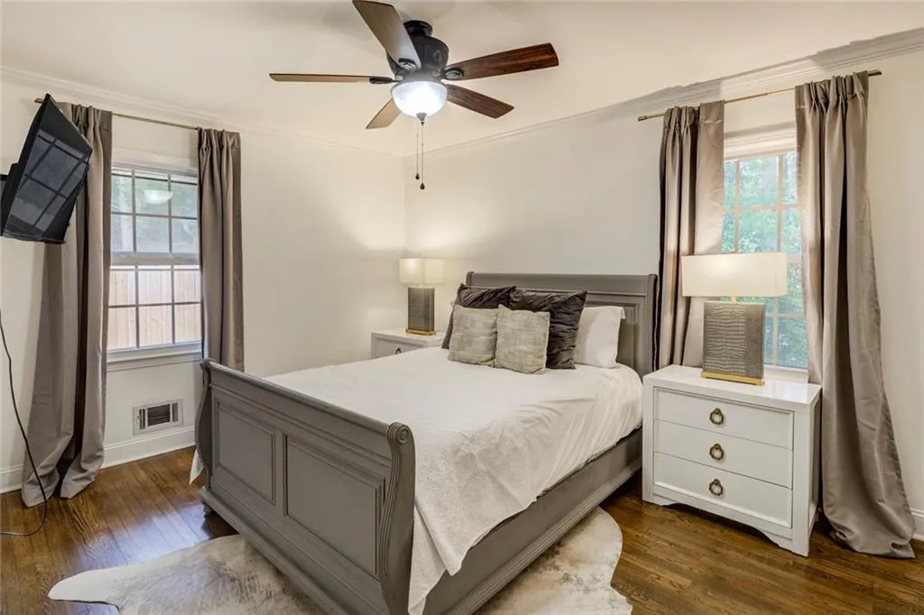 Bedroom with crown molding, dark wood-type flooring, and ceiling fan