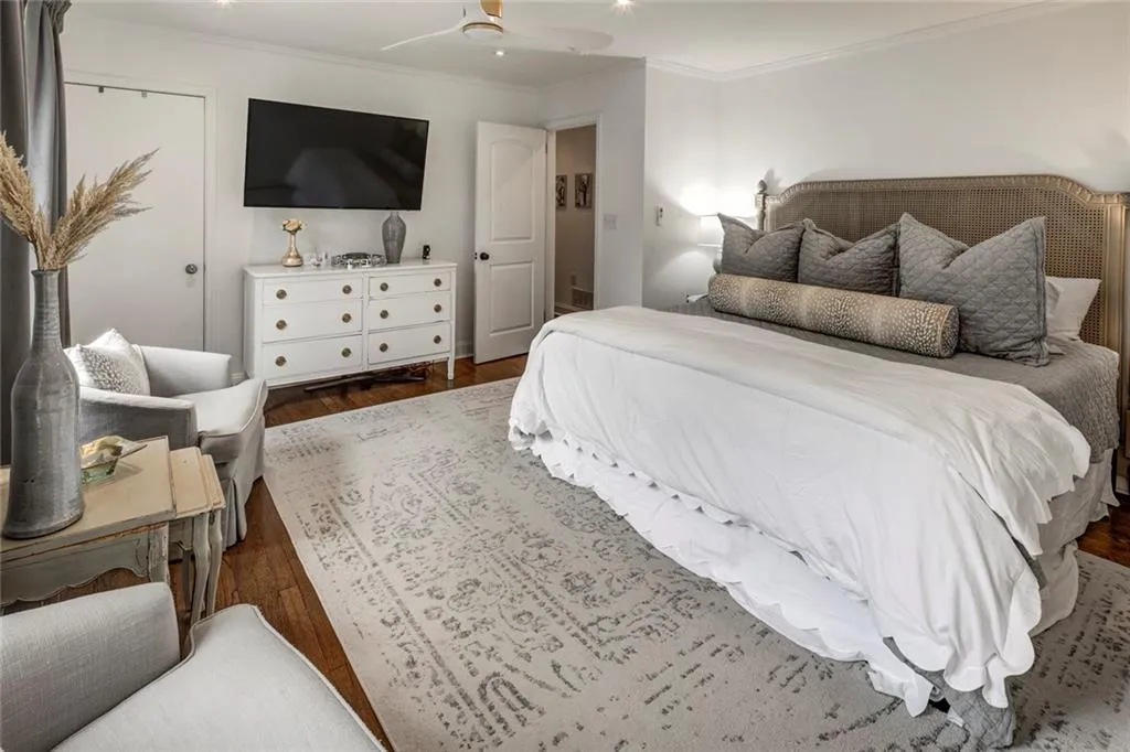 Bedroom featuring dark wood-type flooring, ceiling fan, and crown molding