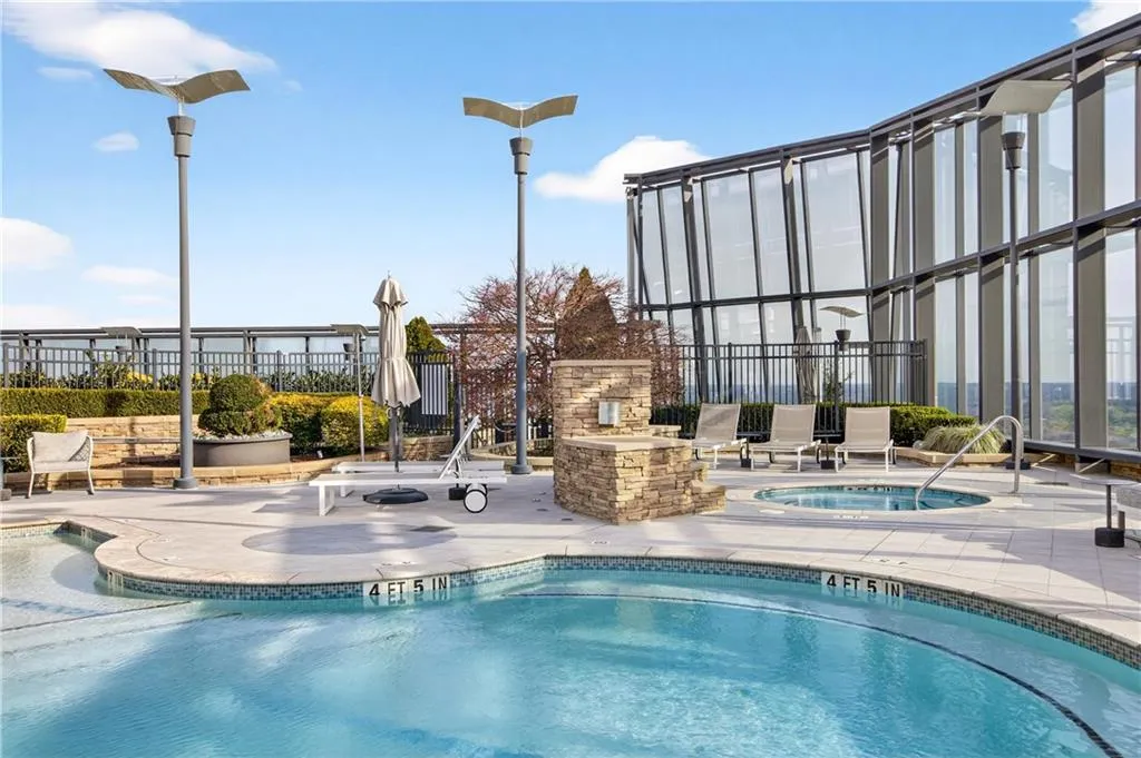 Community pool featuring a hot tub and a patio