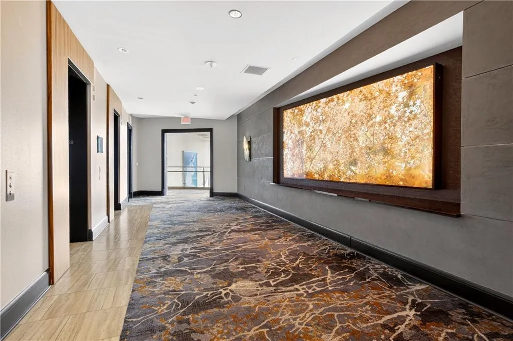 Hallway featuring recessed lighting and an accent wall