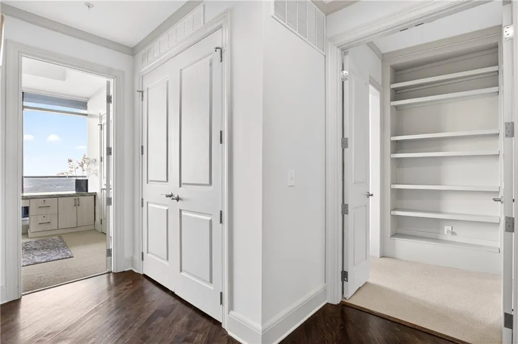 Hallway with dark wood-type flooring and crown molding