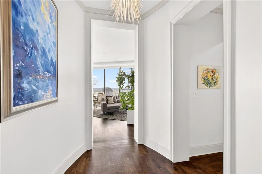 Hallway featuring dark wood-style floors and a chandelier