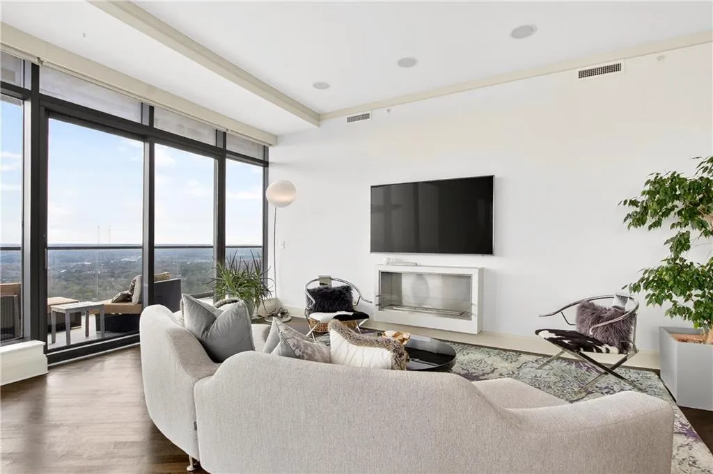 Living room featuring expansive windows and dark wood-style floors