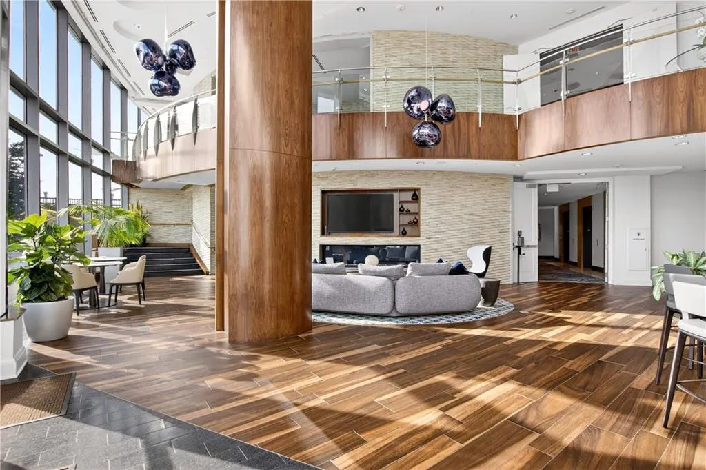 Living area featuring a high ceiling, wood finish floors, a chandelier, and recessed lighting