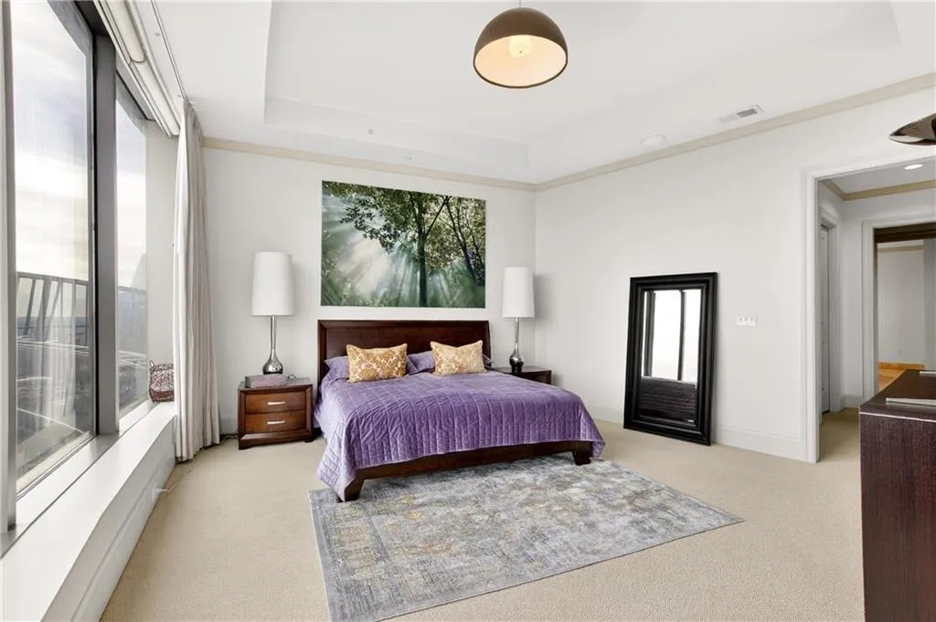 Bedroom featuring light carpet and a tray ceiling