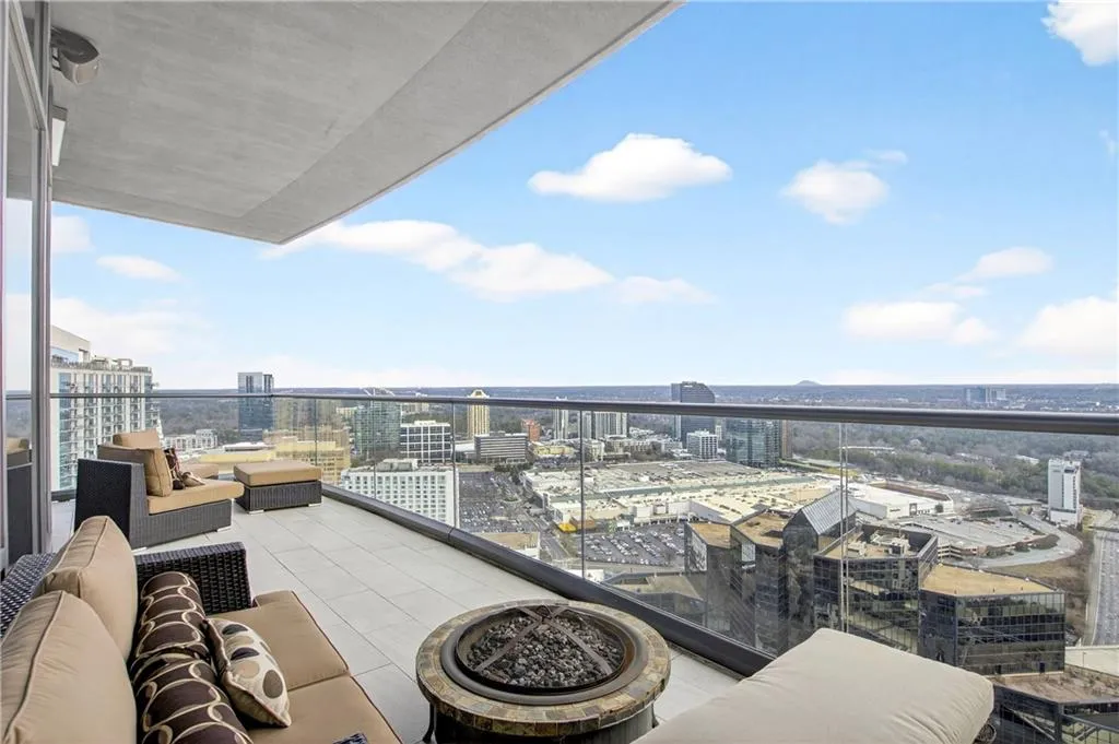 Balcony featuring a city view and an outdoor living space with a fire pit