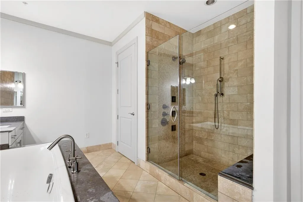 Full bathroom with vanity, a stall shower, light tile patterned floors, and a soaking tub