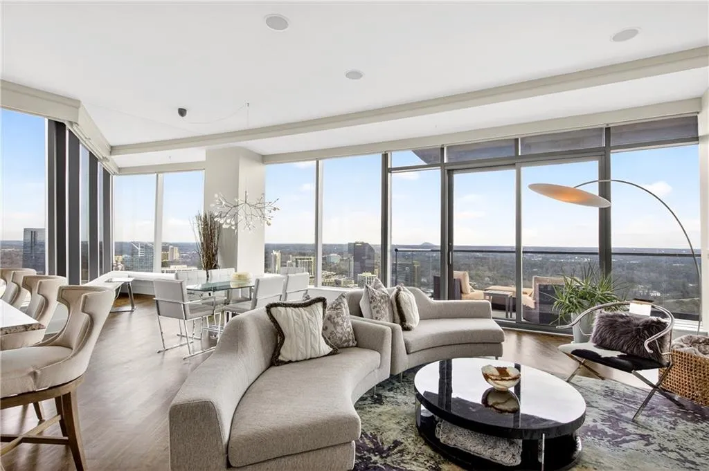 Living area featuring wood finished floors, a wall of windows, and a city view