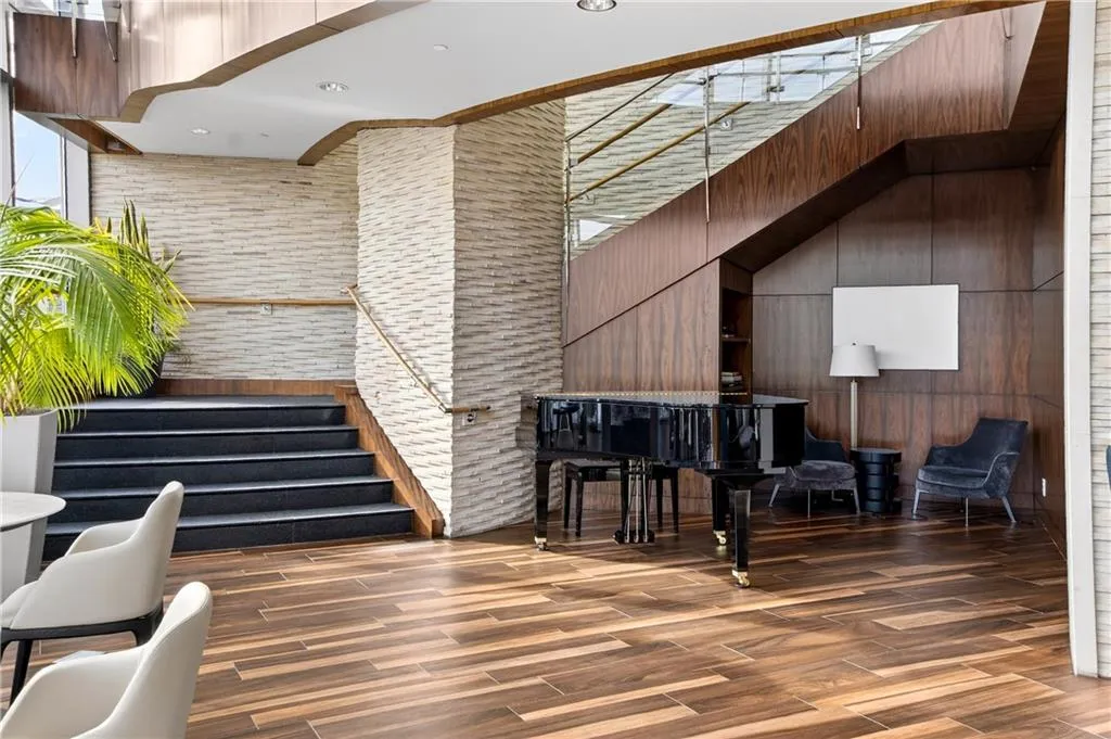 Lobby featuring stairway, a towering ceiling, and wood walls