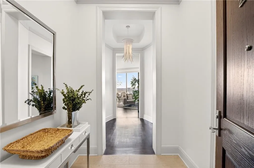 Hall featuring baseboards and a tray ceiling