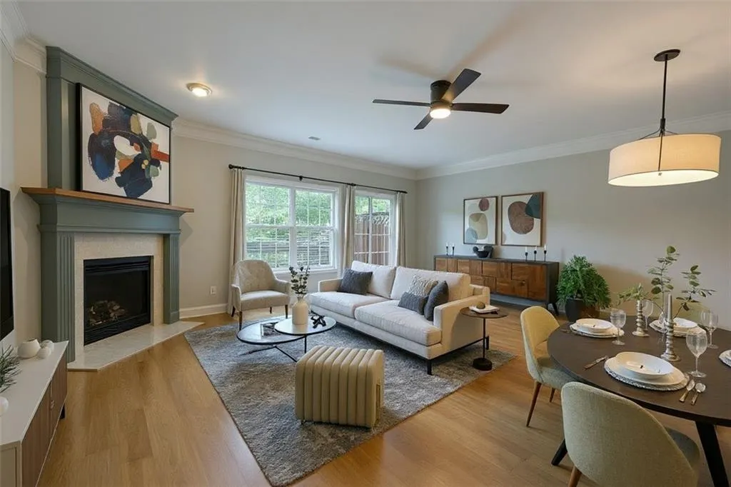Virtual Staging: Living area with light wood finished floors, a fireplace, crown molding, and a ceiling fan