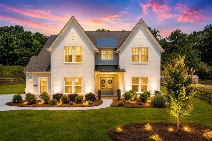 White brick exterior with prominent gables and a dark shingle roof