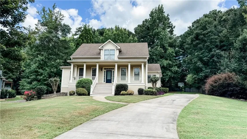 Two-story residence with a covered front porch, white columns, and a dormer window