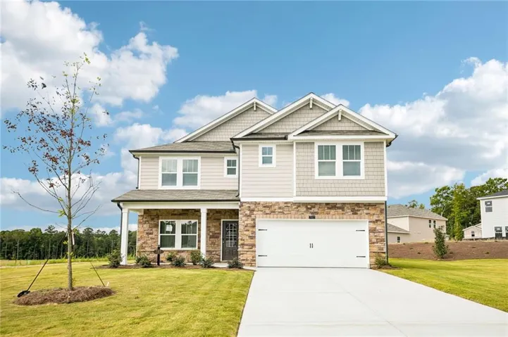 Two-story residence featuring a stone and siding exterior, front-facing two-car garage, covered porch, and a concrete driveway