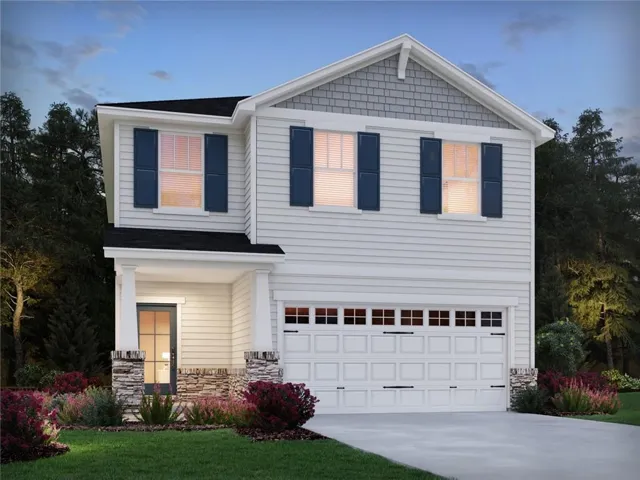 Two-story exterior with light siding, dark shutters, an attached two-car garage, and a covered entry with stone accents