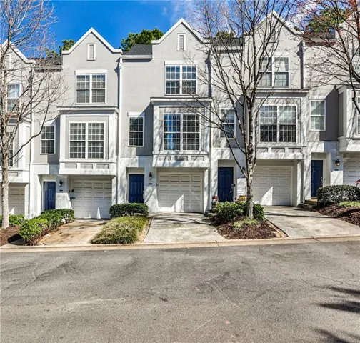 Traditional-style house with stucco siding, concrete driveway, and a garage