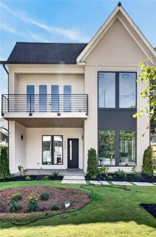 Contemporary exterior with a dark shingle roof and a second-story balcony featuring a horizontal metal railing