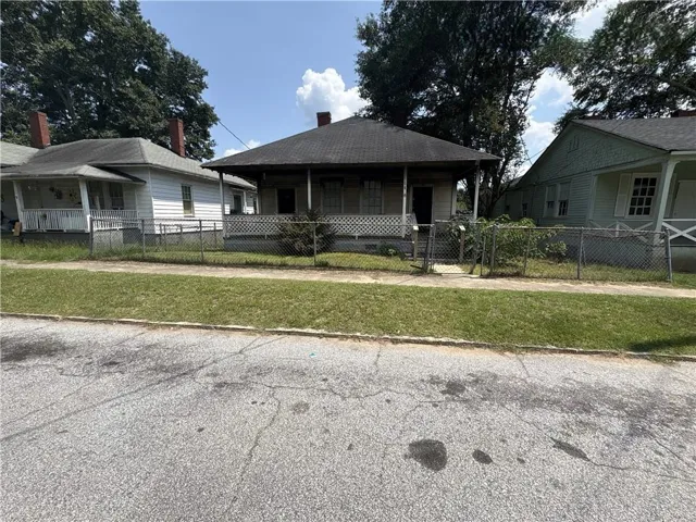 Single-story residence with a covered front porch and chain-link fencing