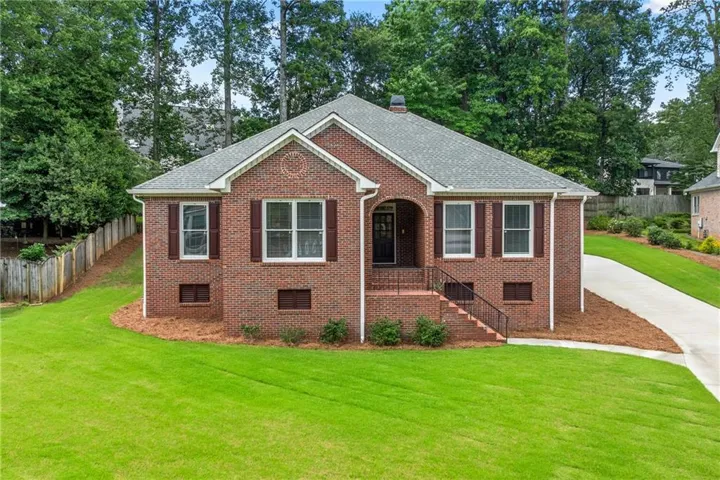 Traditional brick exterior with an arched entryway, gabled roofline, and decorative window shutters