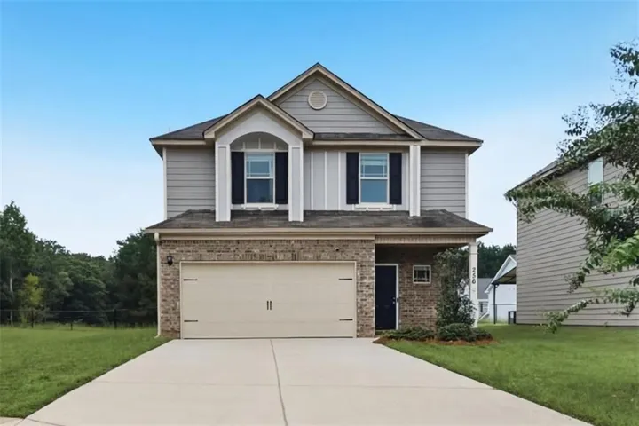 Two-story property featuring brick and siding exterior, an attached garage, a covered entryway, and a concrete driveway