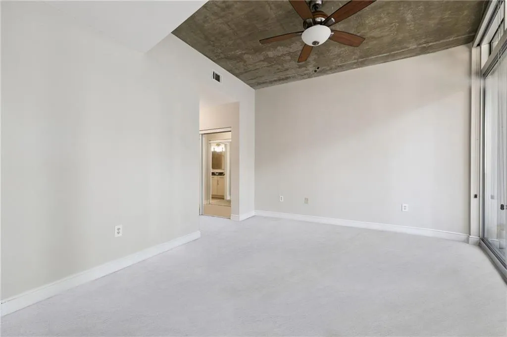 Spare room with a ceiling fan and light carpet