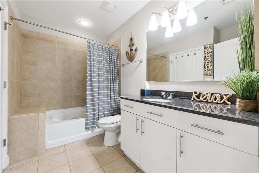 Full bath featuring tile patterned flooring, vanity, and shower / bath combo