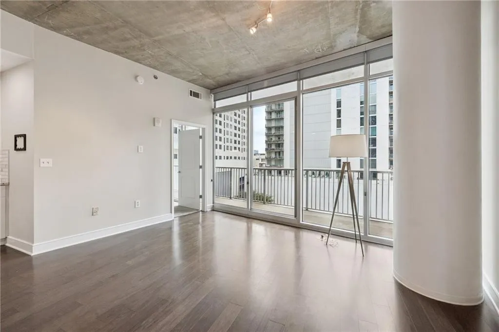 Unfurnished room featuring floor to ceiling windows and dark wood-style flooring