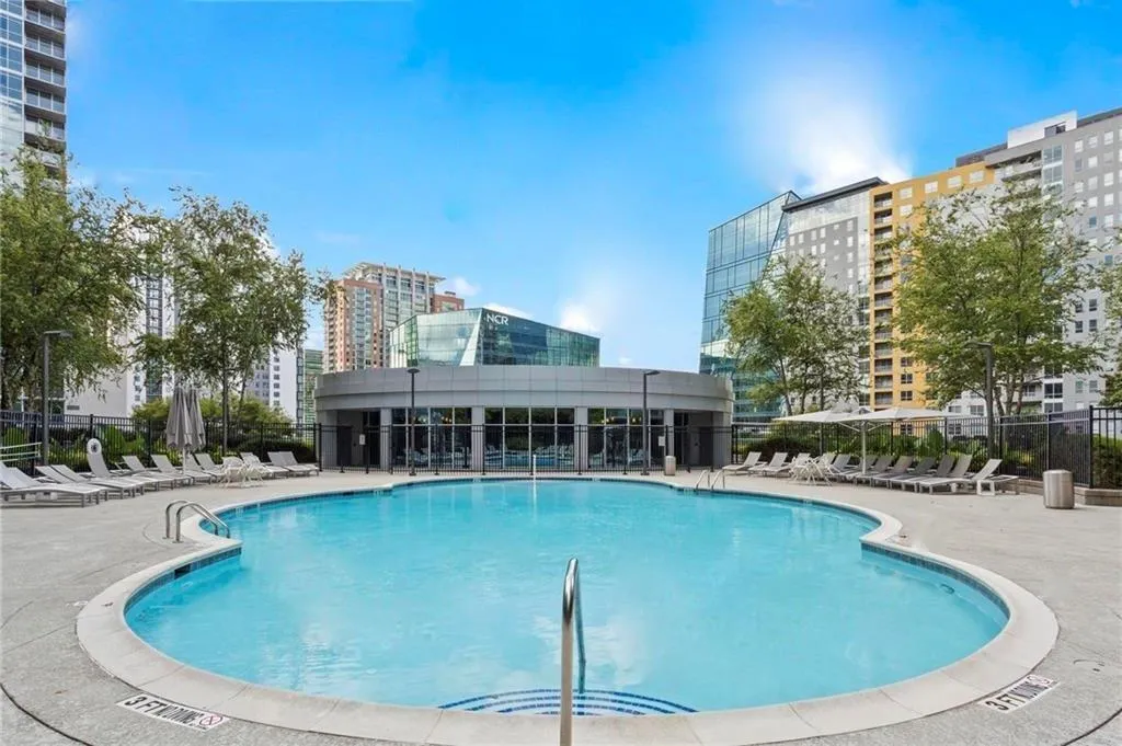 Community pool with a patio area and a city view