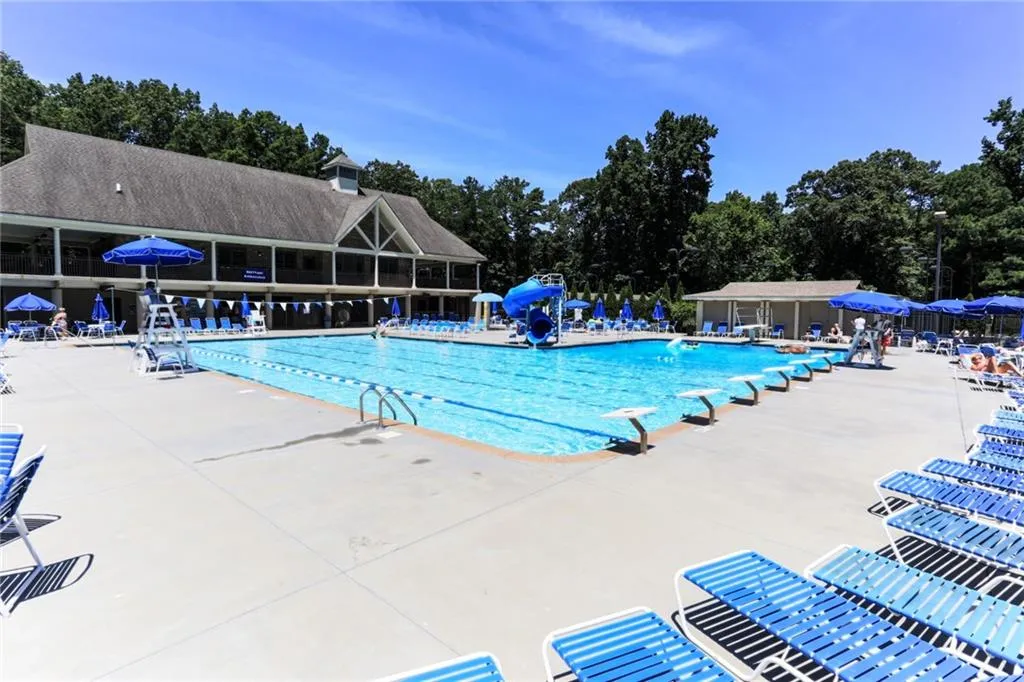 Community pool with a patio area and a water slide