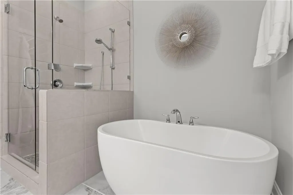 Upgraded freestanding soaking tub compliments the frameless shower with dual showerheads