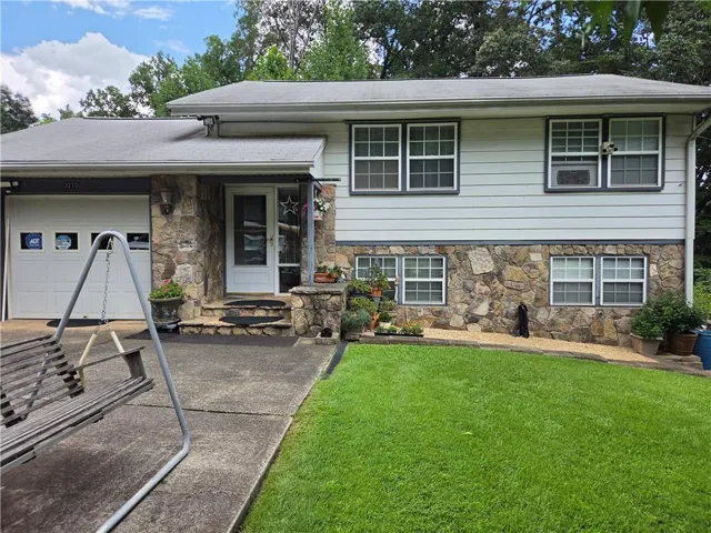 Stone and siding exterior with a single-car garage and a covered entryway