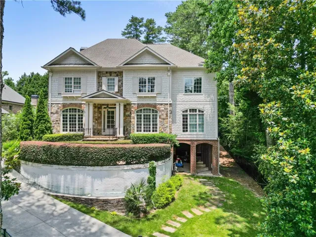 Stately residential exterior featuring stone and shake siding with multiple gables