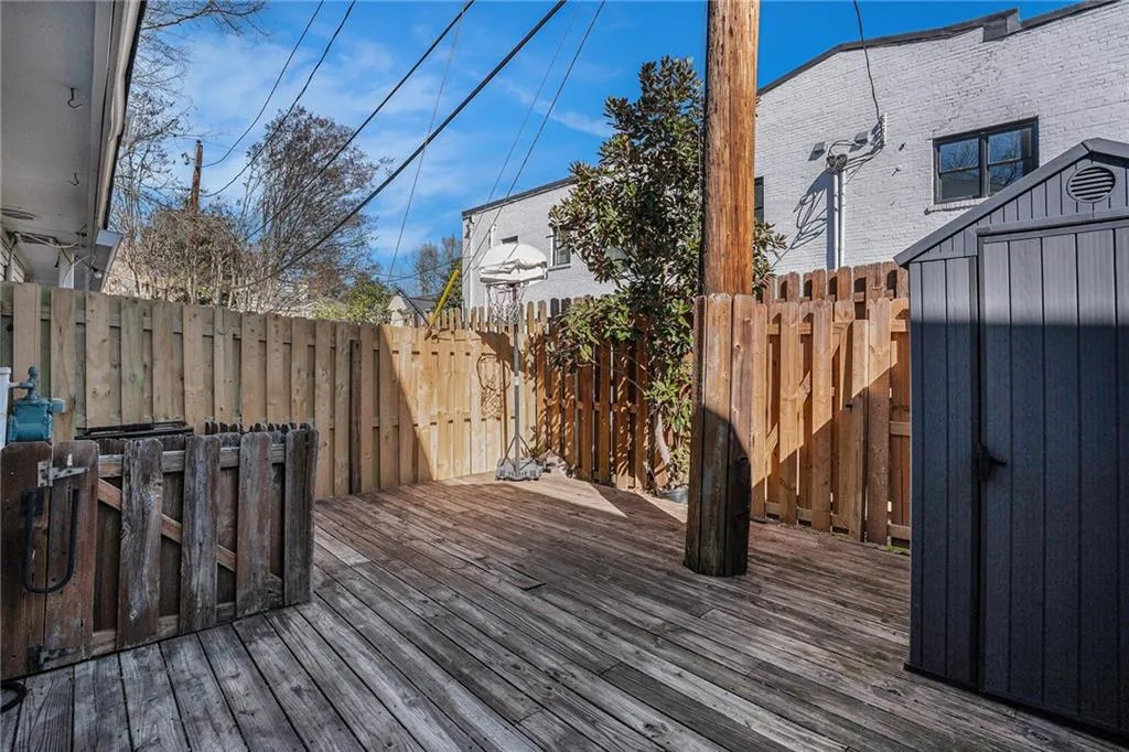 Private fenced, Wooden terrace featuring a storage shed
