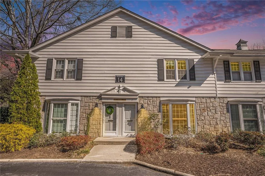 View of front of home with stone siding and a chimney