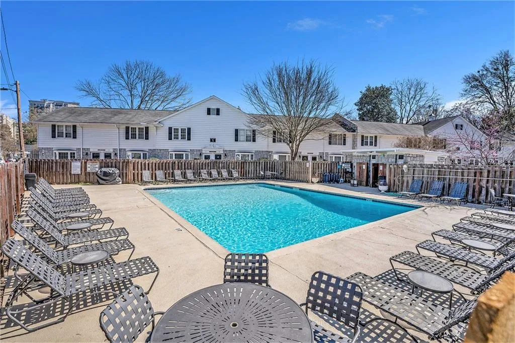 Community pool with fence and a lounging areas