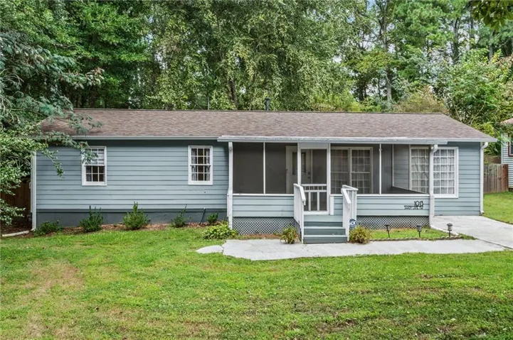 Light blue siding exterior with a screened porch, white trim windows, and a paved driveway