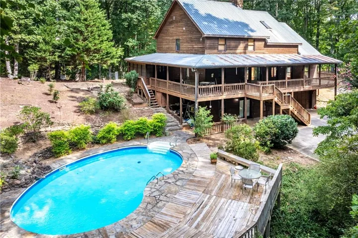 Wood-sided residence with a metal roof, featuring multiple covered balconies and a lower-level deck