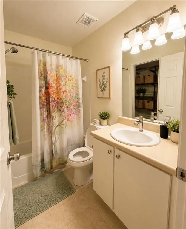 Full bathroom featuring a white vanity with integrated sink, a light-toned countertop, and tile flooring