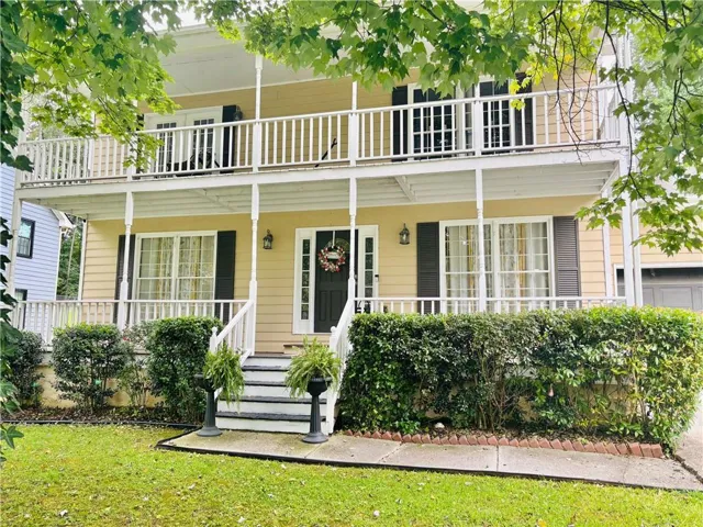 Charming two-story residence featuring a classic front façade with cream-colored siding, black shutters, and black entry door