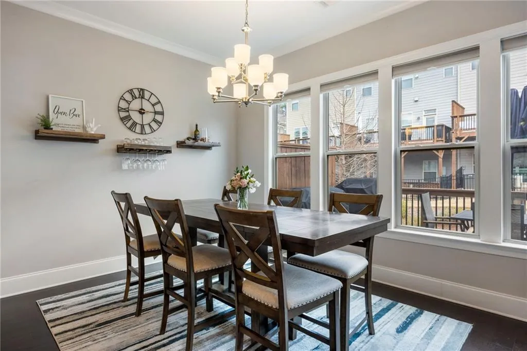 Dining area with dark wood-style flooring, a chandelier, and crown molding